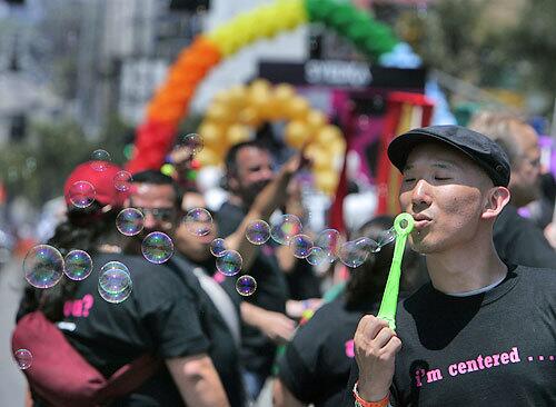 Michael Kang of San Francisco blows bubbles amid a group representing Gay and Lesbian Centers at the L.A. Pride Parade.