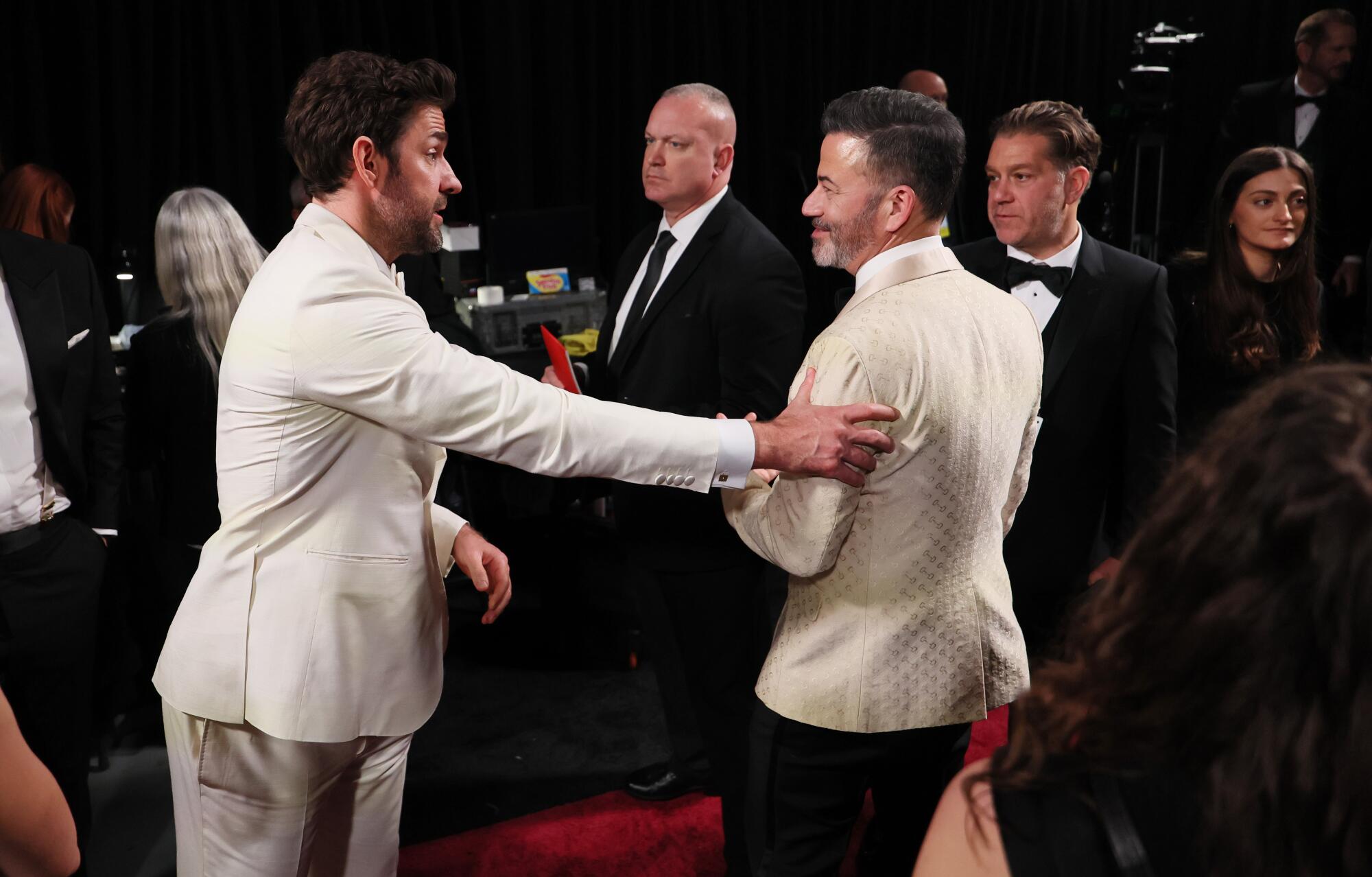 John Krasinski, left, greets and Jimmy Kimmel back stage during the the 96th Annual Academy Awards.