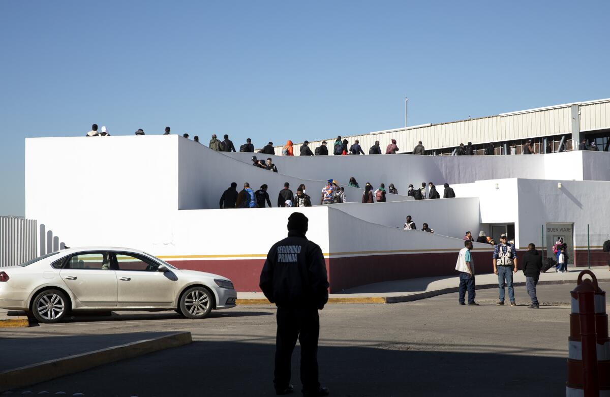 About 80 people walk up an outdoor ramp.