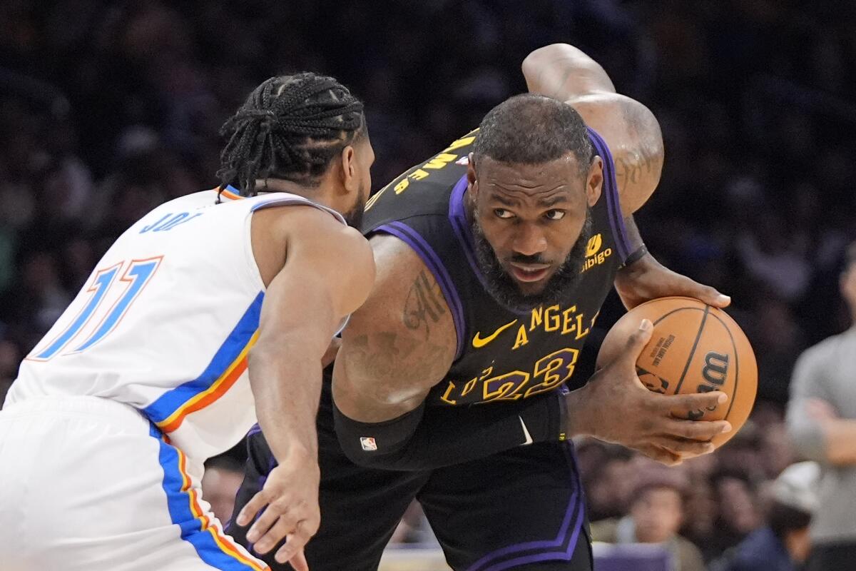 Lakers forward LeBron James, right, tries to get past Thunder guard Isaiah Joe.
