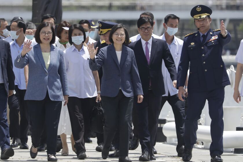 Taiwanese President Tsai Ing-wen, center, waves before an offshore anti-terrorism drill outside the Kaohsiung harbor in Kaohsiung, southern Taiwan, Saturday, June 10, 2023. President Tsai on Saturday said the self-ruled island would work to improve its rescue and defense capabilities with new technologies, stressing that strengthening Taiwan is key to maintaining peace. (AP Photo/Chiang Ying-ying)