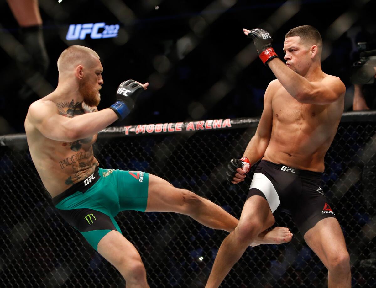 Conor McGregor kicks Nate Diaz during their welterweight rematch at UFC 202.