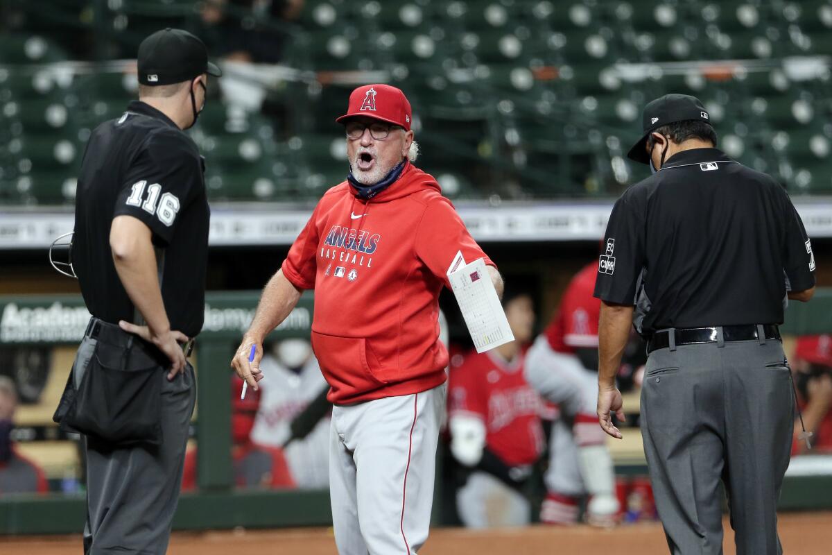 Angels manager Joe Maddon argues with umpires Clint Vondrak and Alfonso Marquez after being ejected.