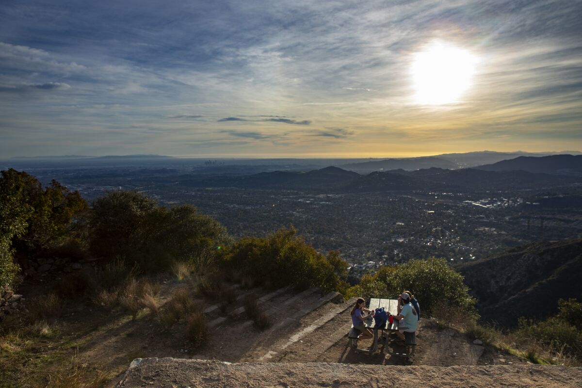 Hikers take in the views from a picnic bench atop Echo Mountain.