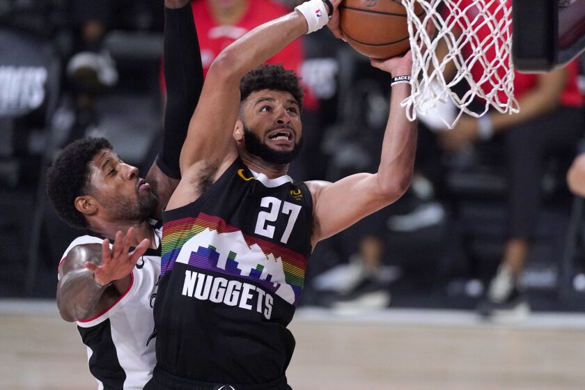 Denver Nuggets' Jamal Murray (27) goes up for a shot as Los Angeles Clippers' Paul George defends during the second half of an NBA conference semifinal playoff basketball game Sunday, Sept. 13, 2020, in Lake Buena Vista, Fla. (AP Photo/Mark J. Terrill)