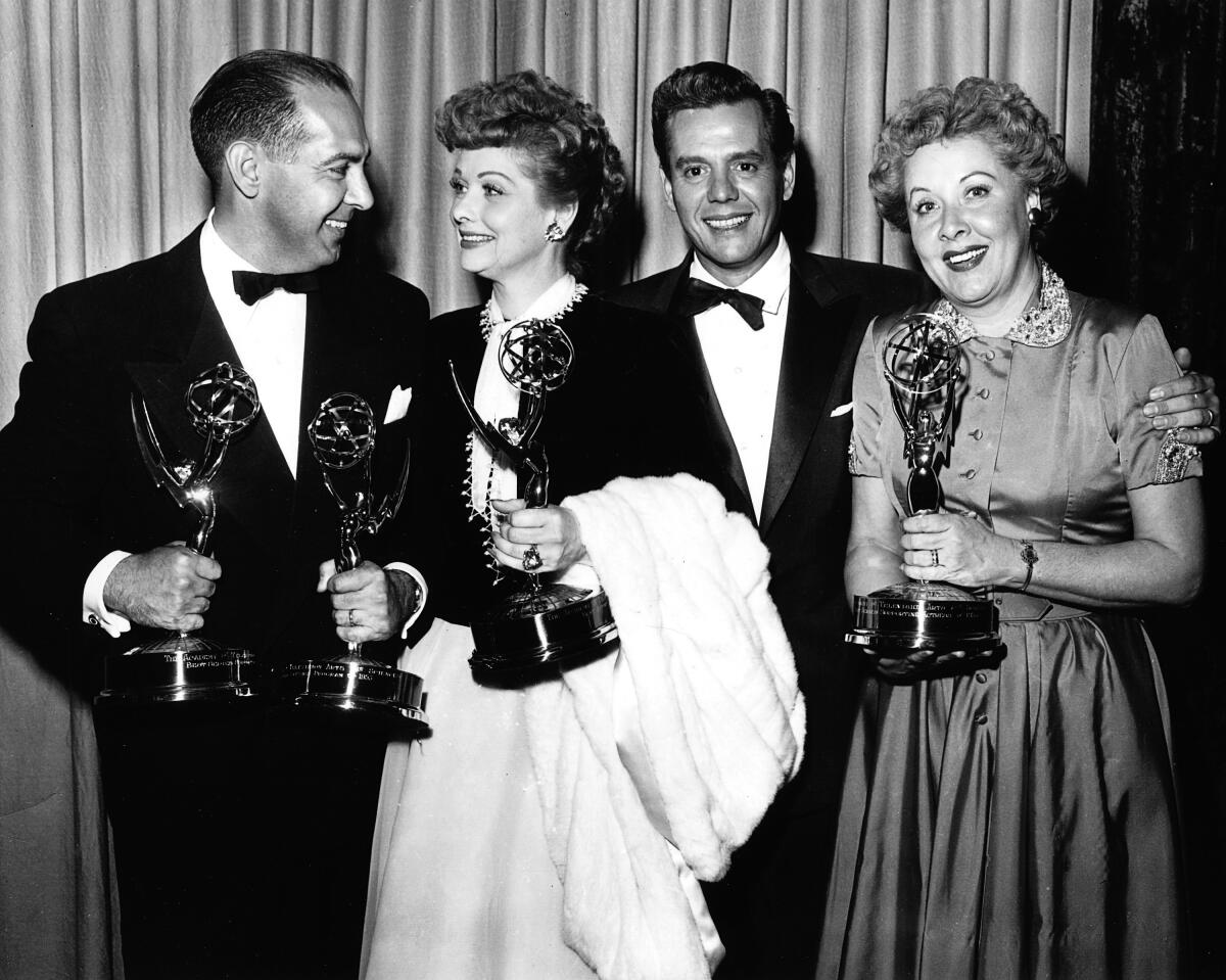 Four people pose with Emmy statuettes in 1954.