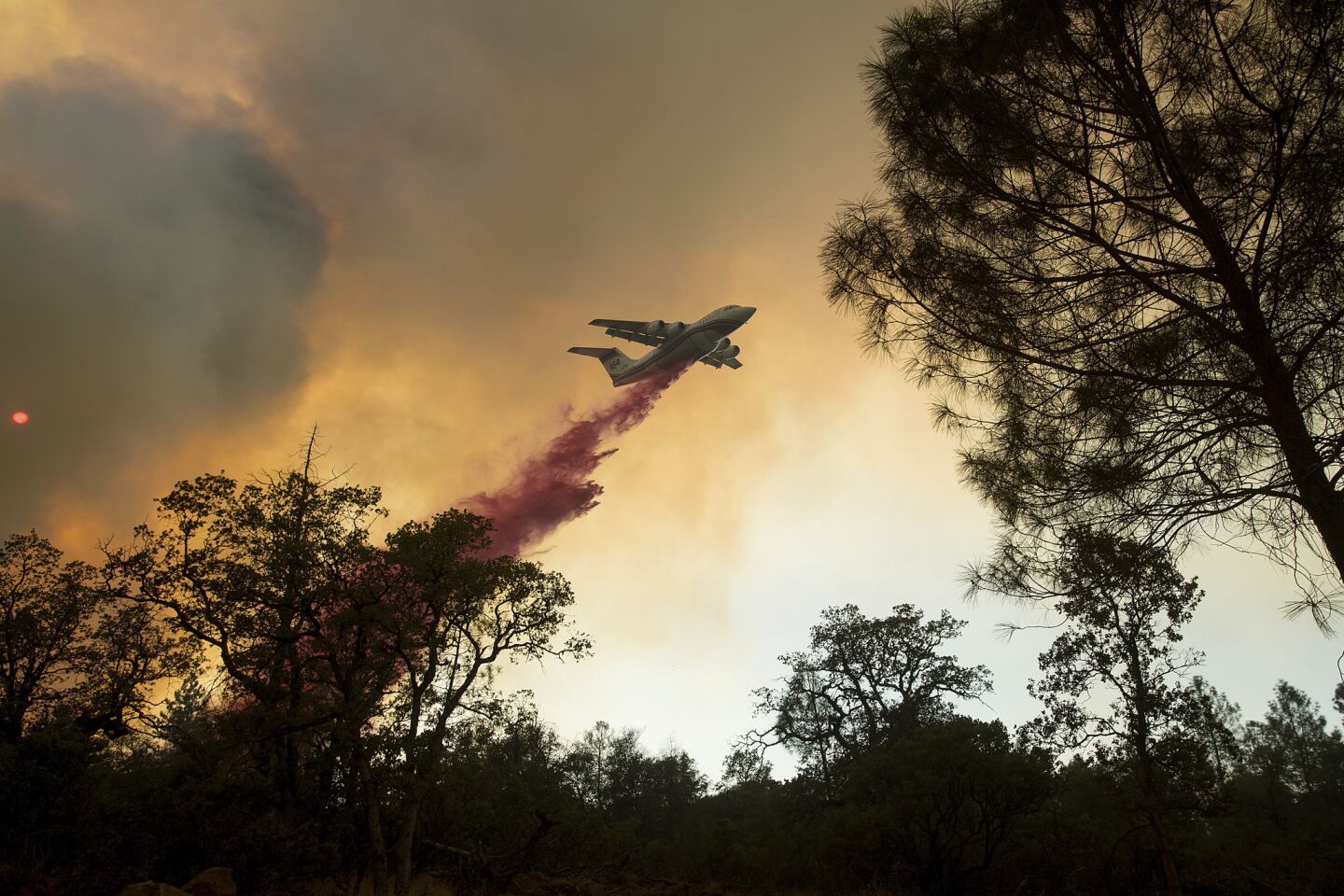 A plane drops retardant while battling a wildfire near Oroville.