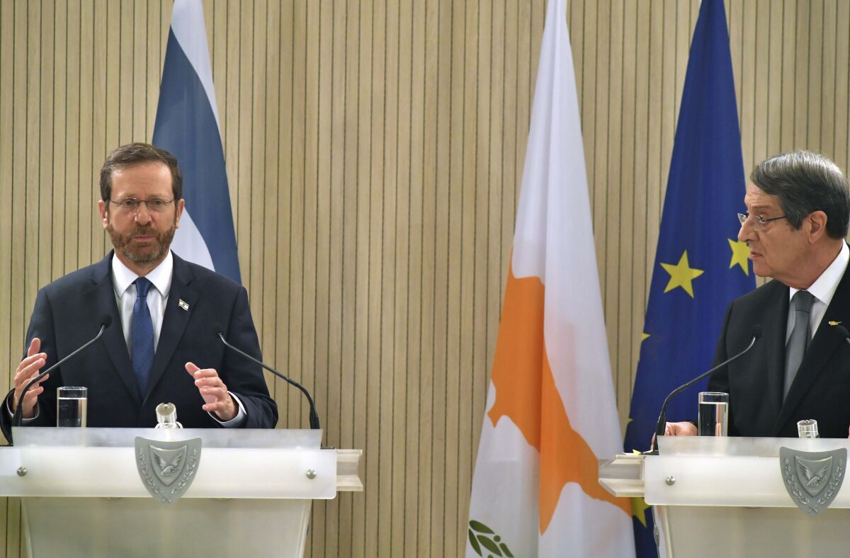 Israeli President Isaac Herzog, left, and Cypriot President Nicos Anastasiades speak to the media, during a press conference after their meeting at the presidential palace in Nicosia, Cyprus, Wednesday, March 2, 2022. Herzog is in Cyprus on a day official visit. (Iakovos Hatzistavrou/Pool via AP)