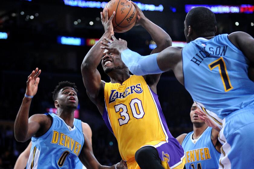 Lakers forward Julius Randle drives between Nuggets Emmanuel Mudiay, left, and J.J. Hickson during the first quarter of a game against Denver at Staples Center on Nov. 3.