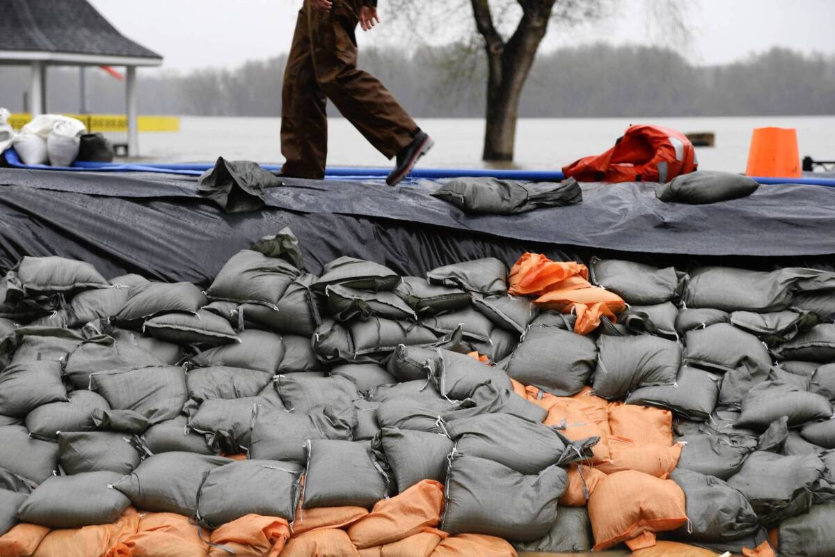 A sandbag levee holds back floodwaters in Clarksville, Mo. Communities along Midwestern waterways monitored and fortified makeshift levees holding back flooding that meteorologists said could worsen or be prolonged by looming storms.