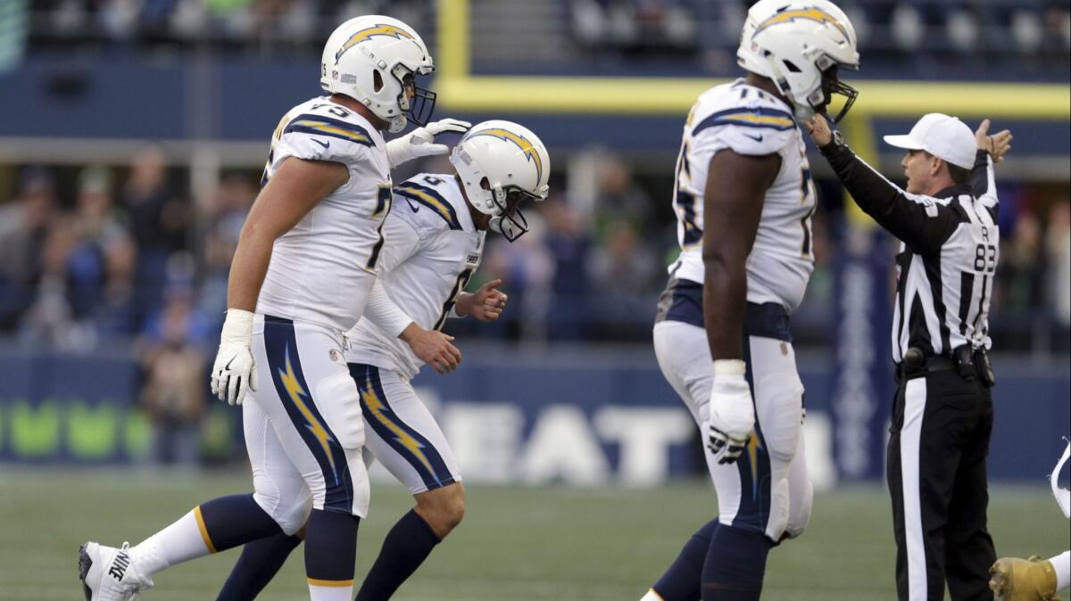 Chargers kicker Caleb Sturgis (6) gets a pat from Michael Schofield after missing a field-goal try against the Seattle Seahawks in the second half.