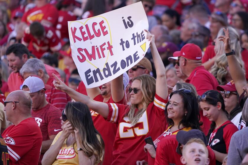 A fan holds a Kelce-Swift sign during the first half of a game between the Chicago Bears and Kansas City Chiefs