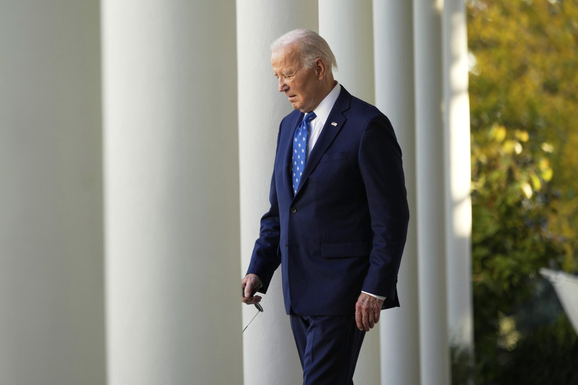 A man walks next to white pillars