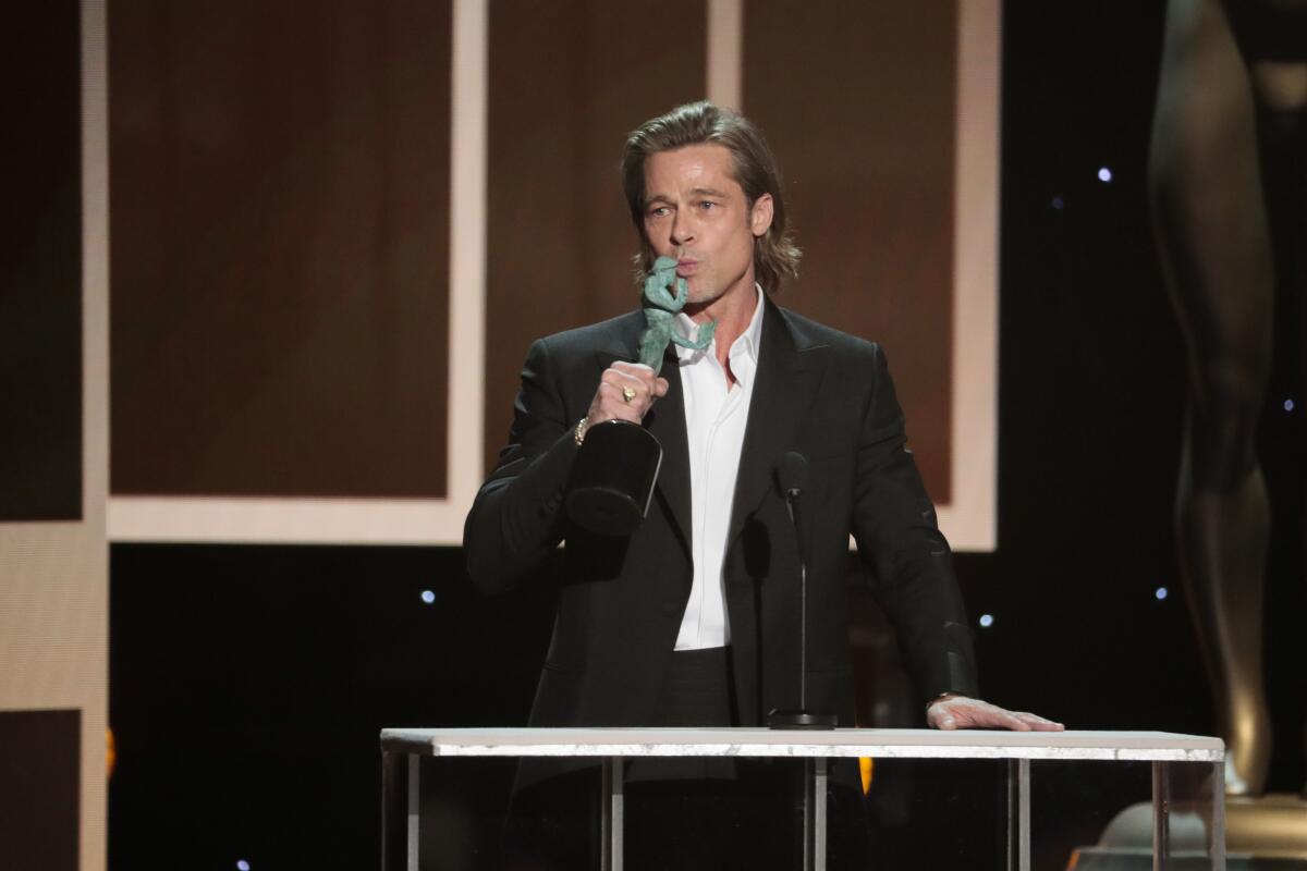 Brad Pitt gives the statue a peck as he accepts the 2020 SAG supporting actor award.