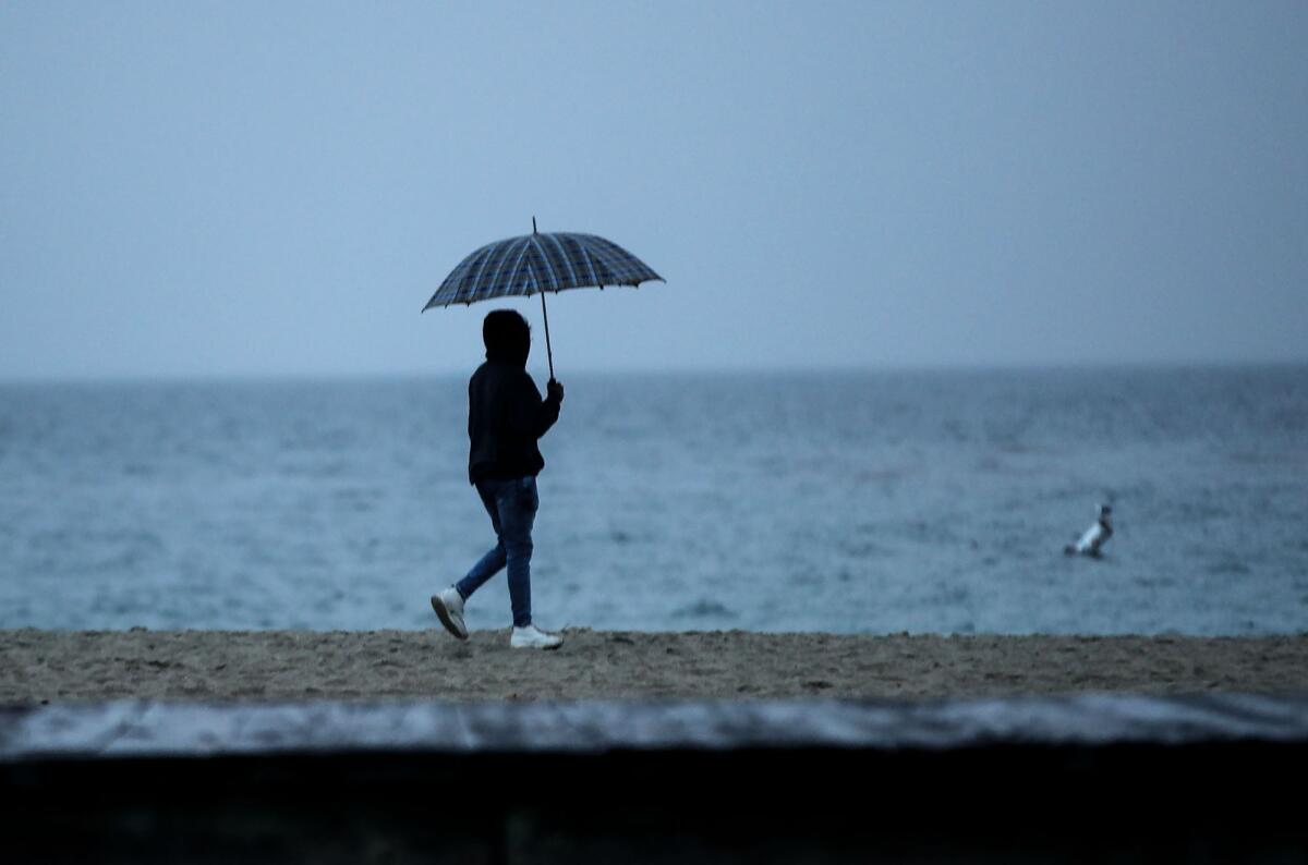 A beach-goer walks in the sand at Main Beach Park.