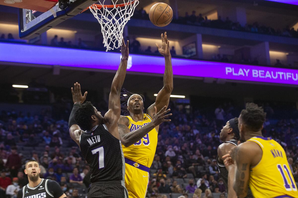 Lakers' Dwight Howard puts up a shot as Sacramento Kings forward Chimezie Metu defends.