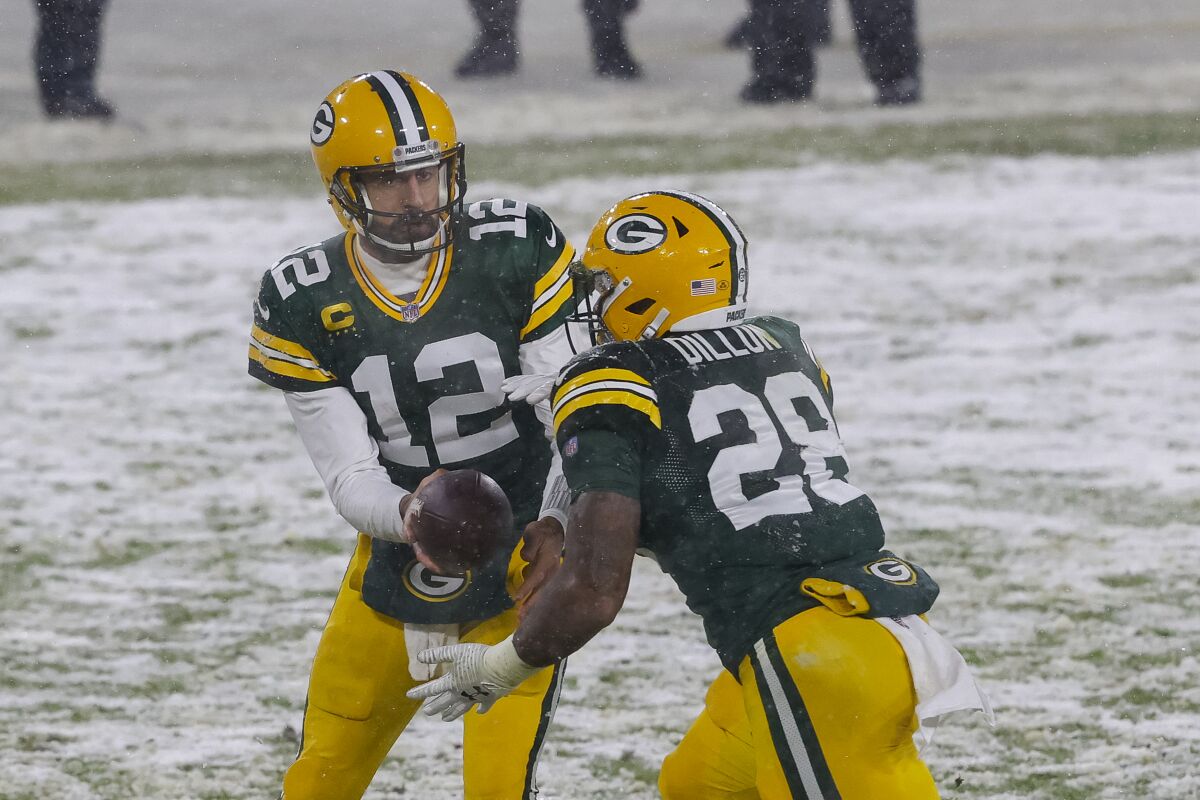 Green Bay Packers quarterback Aaron Rodgers hands off to running back AJ Dillon against the Tennessee Titans on Dec. 27.