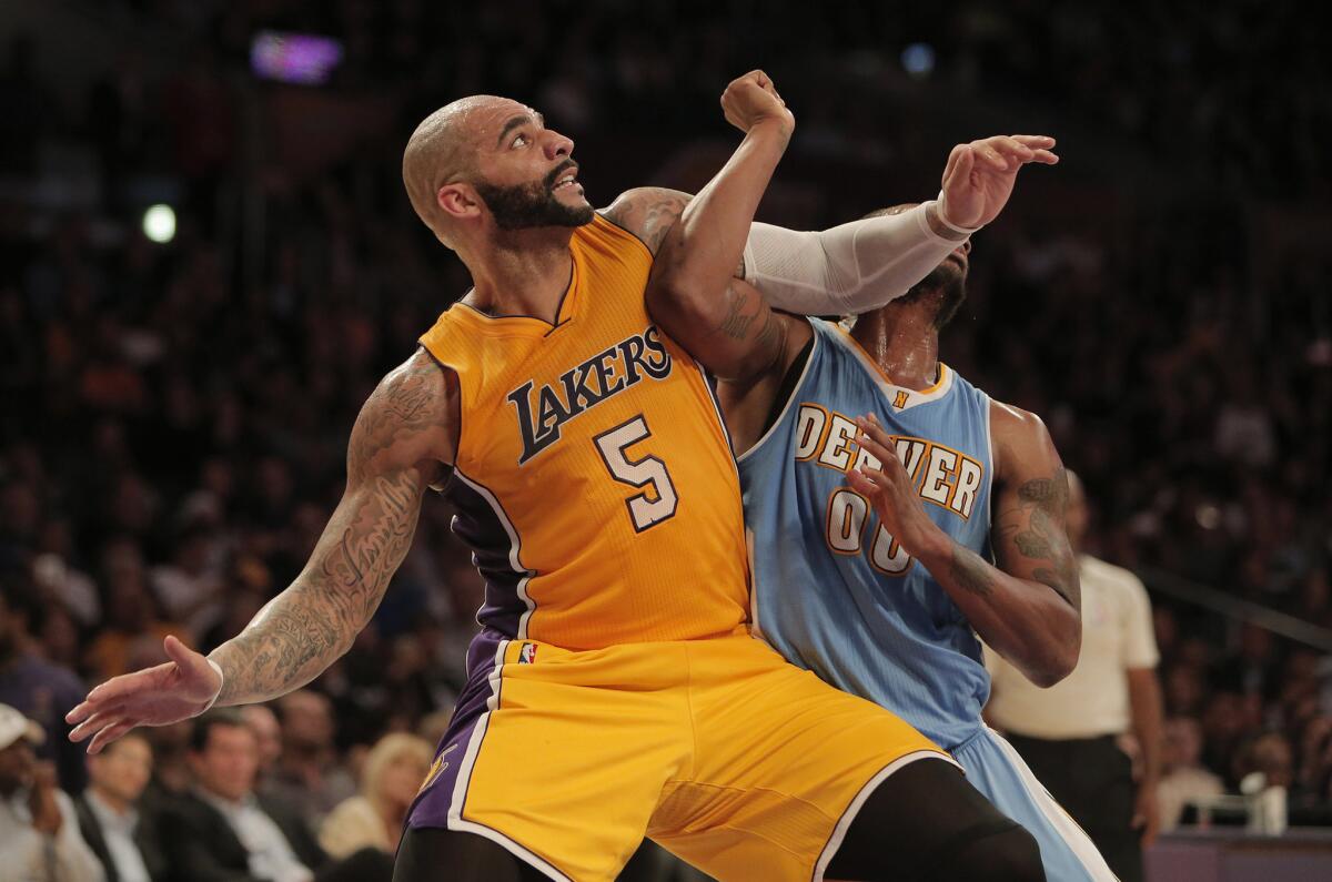 Carlos Boozer blocks out Denver forward Darrell Arthur late in the fourth quarter of the Lakers' 106-96 loss to the Nuggets at Staples Center.