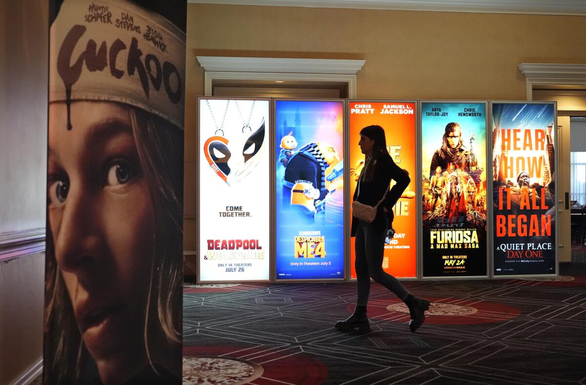 Un visitante pasa junto anuncios de próximas películas el día inaugural de CinemaCon 2024