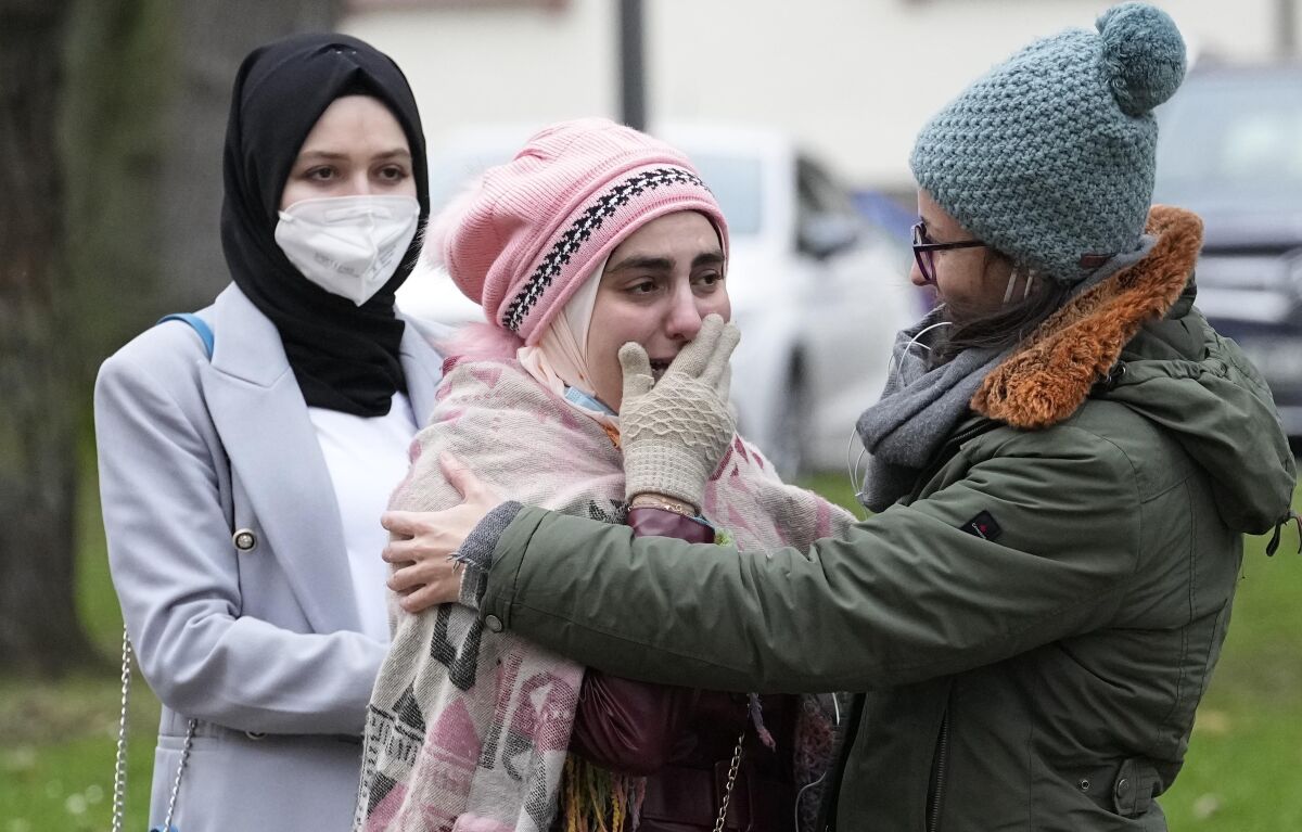 Syrian women Yasemine, center, who lost her father and brother in Syria, reacts after the verdict in front of the court in Koblenz, Germany, Thursday, Jan. 13, 2022. A German court has convicted a former Syrian secret police officer of crimes against humanity for overseeing the abuse of detainees at a jail near Damascus a decade ago. The verdict Thursday in the landmark trial has been keenly anticipated by Syrians who suffered abuse or lost relatives in the country’s long-running conflict. (AP Photo/Martin Meissner)