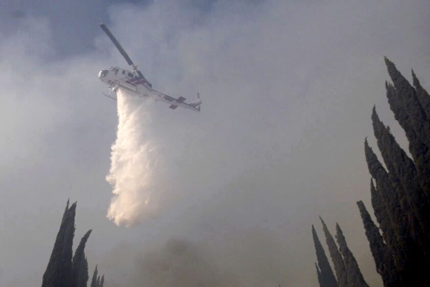 A helicopter makes a water drop on the Union fire in the Jurupa Valley on June 25.