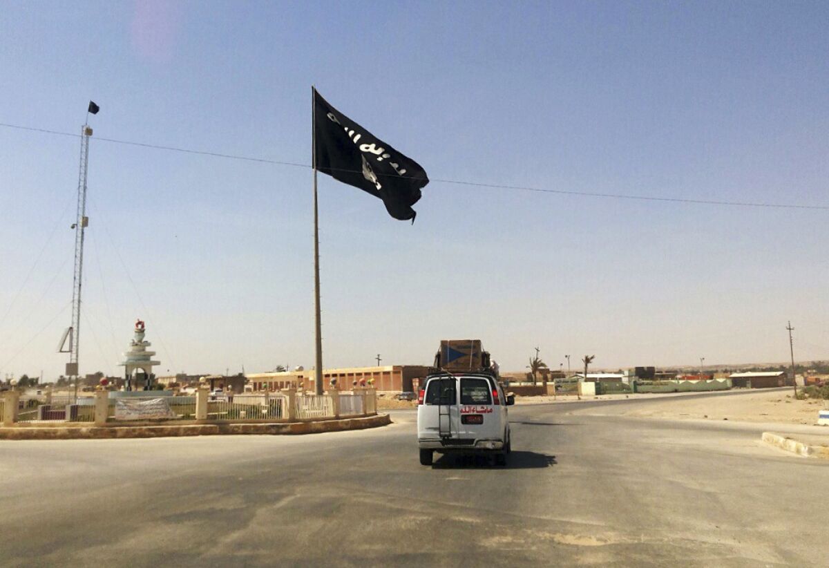 FILE - A motorist passes by a flag of the Islamic State group in central Rawah, 175 miles (281 kilometers) northwest of Baghdad, Iraq, July 22, 2014. Members of the global coalition fighting the Islamic State group are meeting in Morocco on Wednesday May 11, 20222 to discuss ongoing efforts in the campaign. The meeting is a reminder of the persistent threat from the extremist group despite the overwhelming preoccupation with Russia’s war on Ukraine. (AP Photo, File)