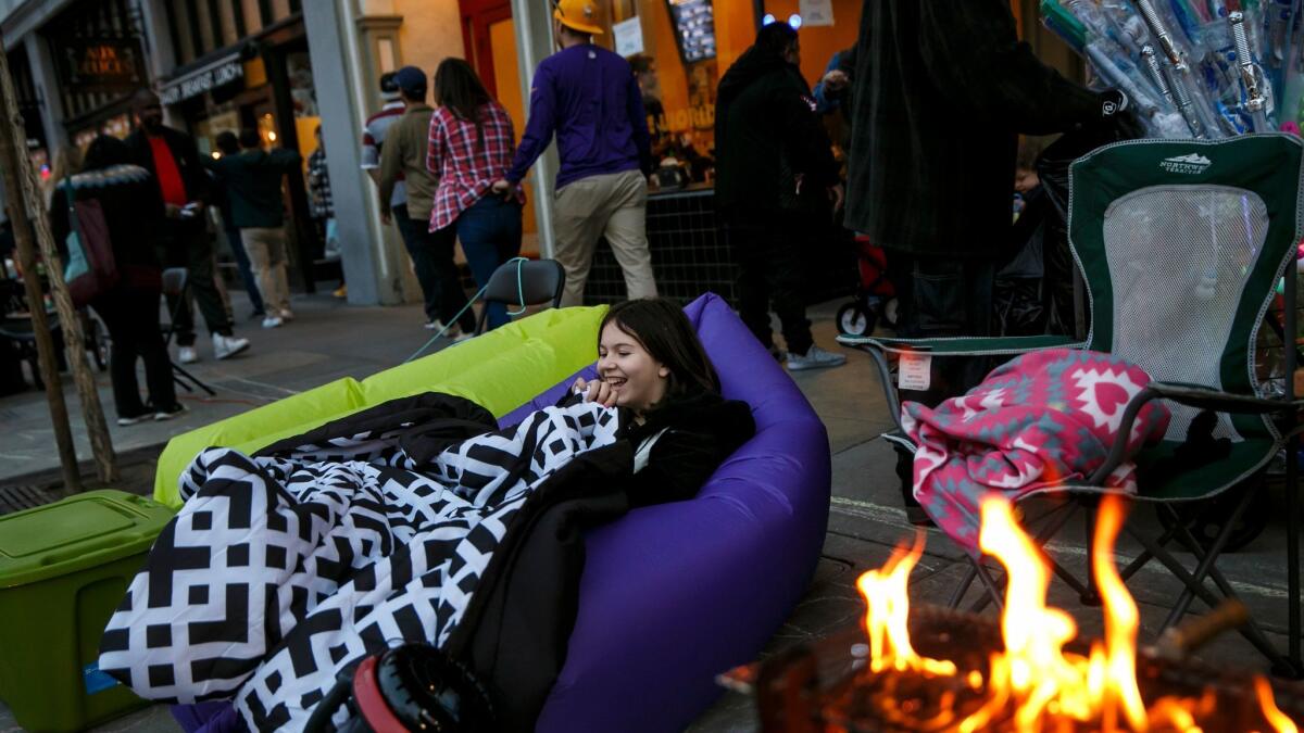 Hailey Cox, 10, finds comfort from the cold along Colorado Boulevard in Pasadena.