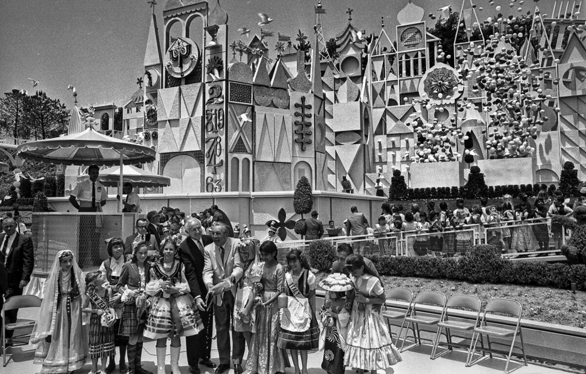May 30, 1966: Walt Disney pours water from canteen into a channel through new Disneyland attraction, "It's a Small World."