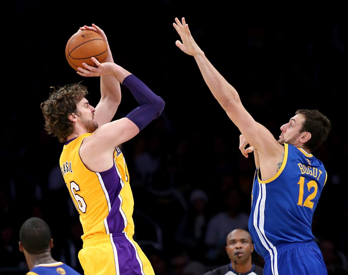 Lakers power forward Pau Gasol shoots and scores over the defense of Warriors center Andrew Bogut in the fourth quarter Friday night at Staples Center.