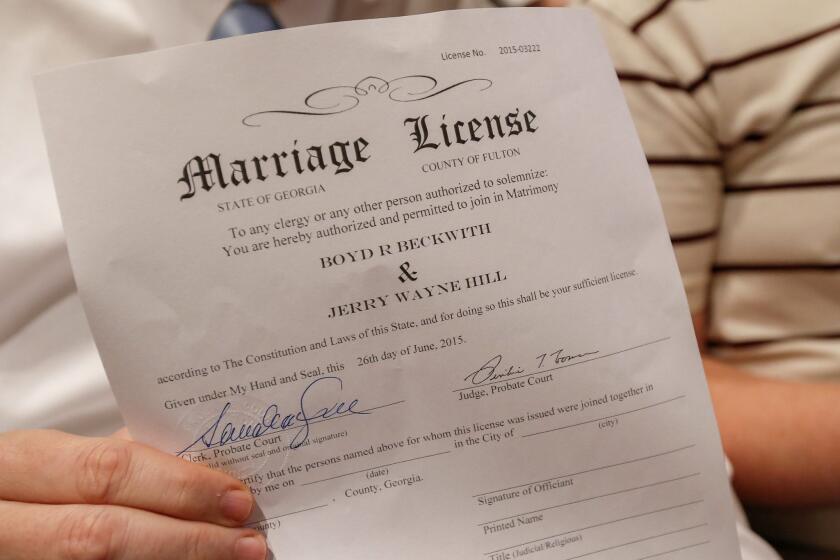 Boyd Beckwith holds his marriage license with his soon-to-be spouse Jerry Hill during a mass wedding ceremony in Atlanta on Friday.
