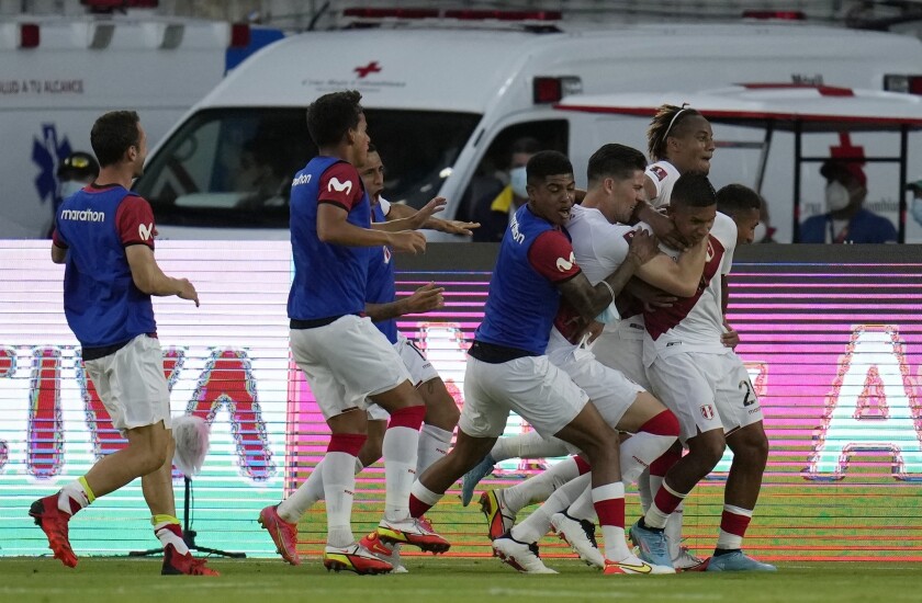 Edison Flores (derecha), de la selección de Perú, es felicitado por sus compañeros tras anotar ante Colombia en un cotejo de la eliminatoria mundialista, disputado el viernes 28 de enero de 2022 en Barranquilla (AP Foto/Fernando Vergara)