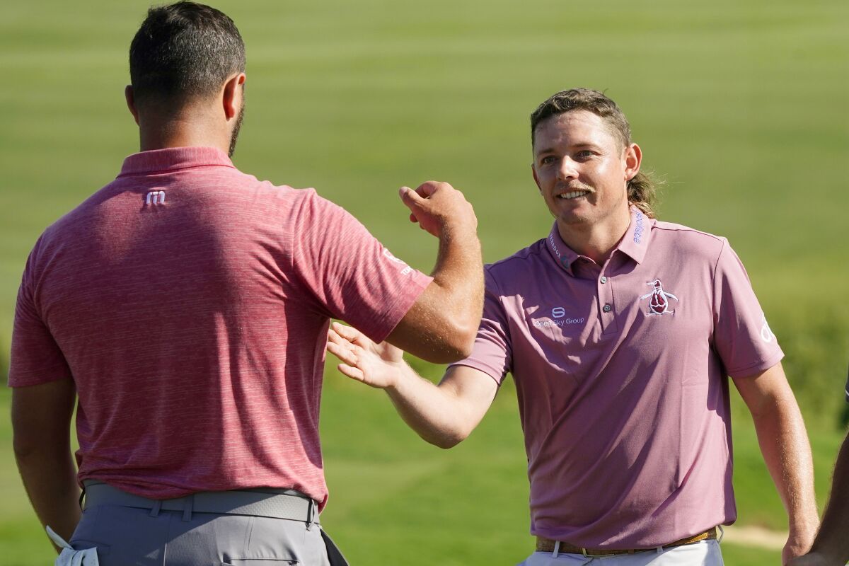 Cameron Smith, right, greets Jon Rahm, of Spain, after Smith won the Tournament of Champions golf event, Sunday, Jan. 9, 2022, at Kapalua Plantation Course in Kapalua, Hawaii. (AP Photo/Matt York)