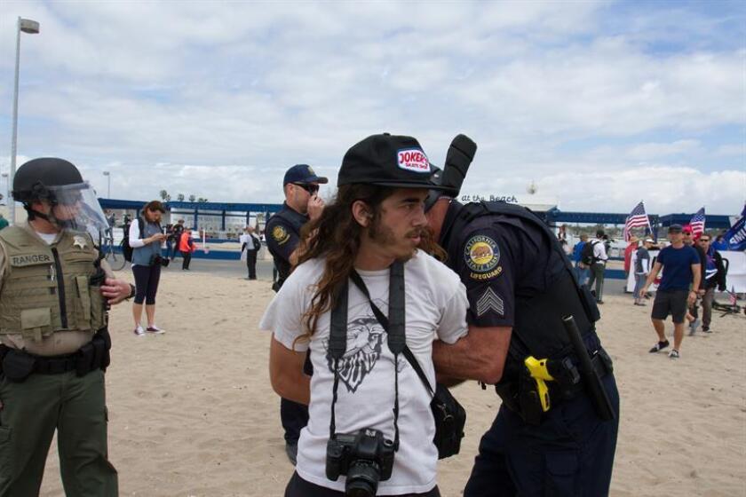 Un manifestante es detenido mientras opositores se enfrentan con seguidores del presidente estadounidense Donald Trump hoy, sábado 25 de marzo de 2017, durante una marcha en la ciudad de Huntington Beach, CA (Estados Unidos). EFE/Archivo