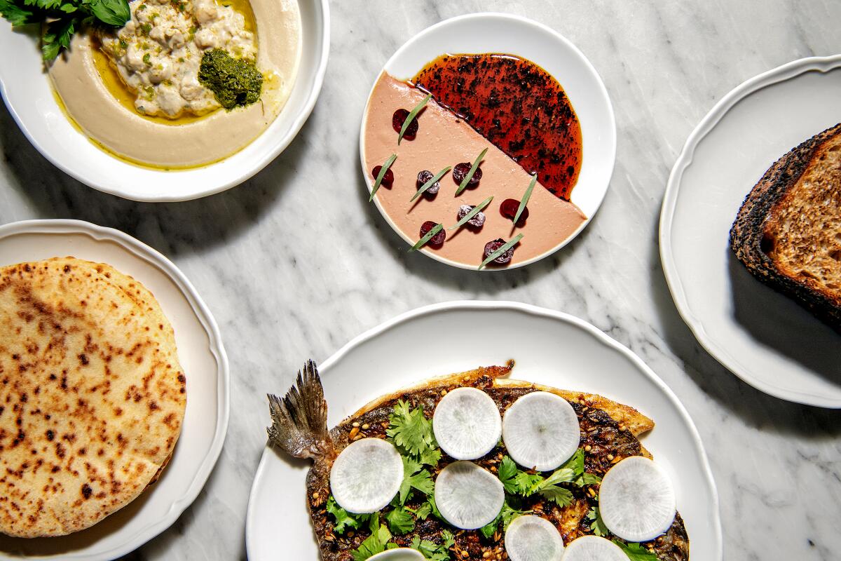 LOS ANGELES , CA - OCTOBER 13: A spread from Bavel including, clockwise from top left: hummus, chicken liver pate and the grilled dorade in Los Angeles on Thursday, Oct. 13, 2022 in Los Angeles , CA. (Mariah Tauger / Los Angeles Times)