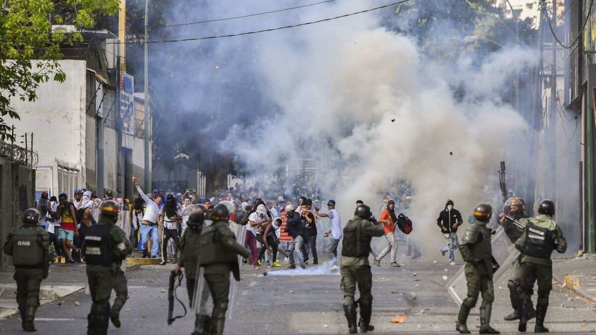 Riot police clash with opposition demonstrators during a protest against the government of President Nicolas Maduro.
