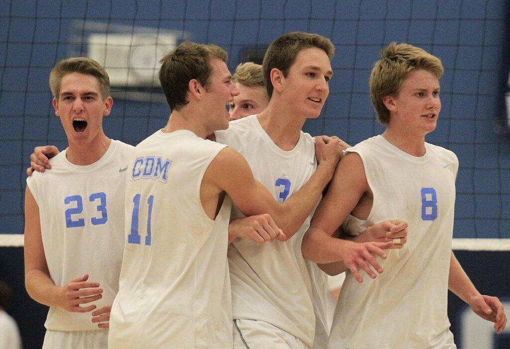 Corona del Mar High players react after Ryan Moss, second from right, scored the final point in a nonleague match against Loyola in Newport Beach on Wednesday.