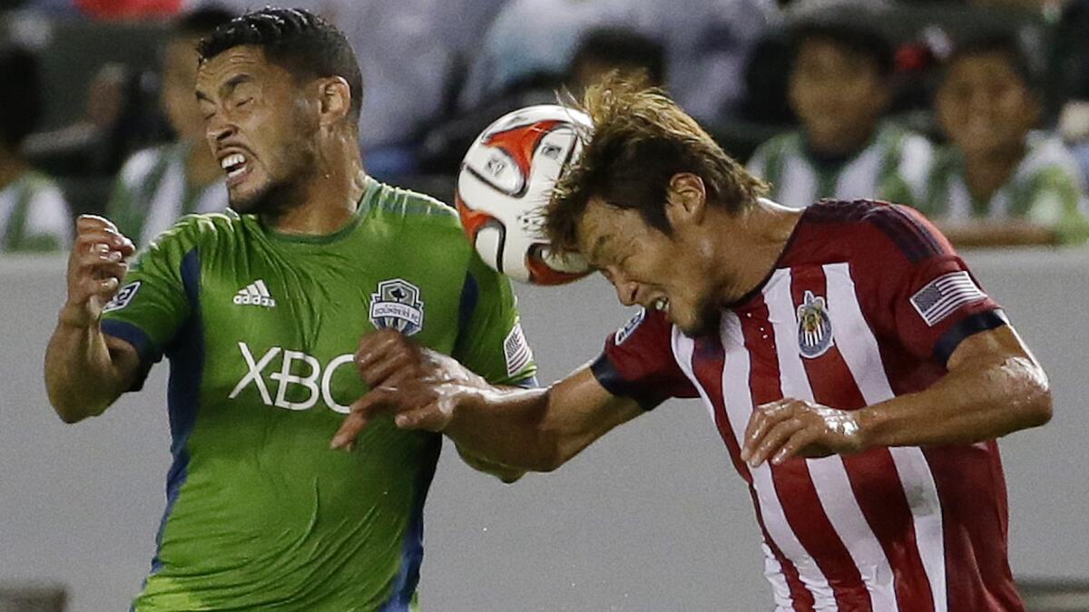 Chivas USA's Akira Kaji, right, heads the ball away from Seattle's Lamar Neagle during the first half of Chivas USA's 4-2 loss Wednesday.