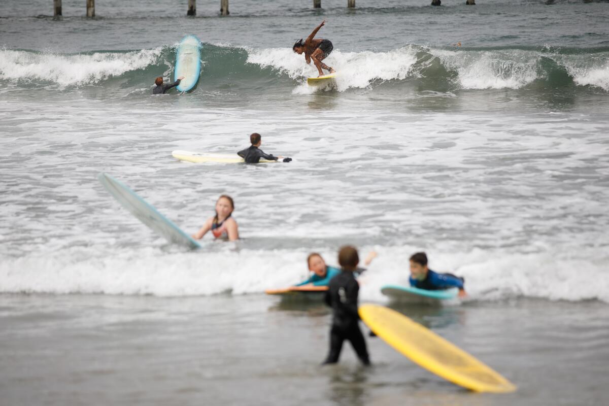 People hit the waves at Ocean Beach on Aug. 19, the day before the arrival of Tropical Storm Hilary.