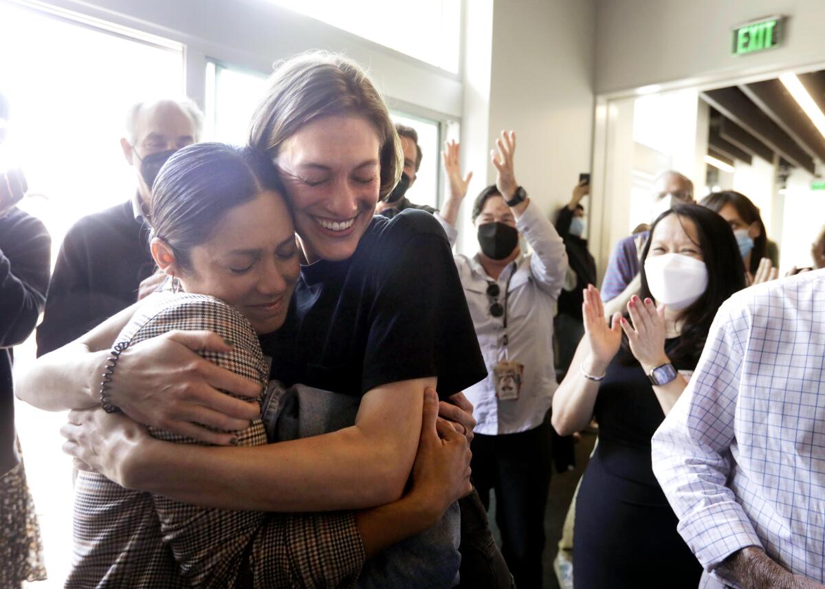 Los Angeles Times photographer Christina House, left, is hugged by former Times videographer Claire Collins 