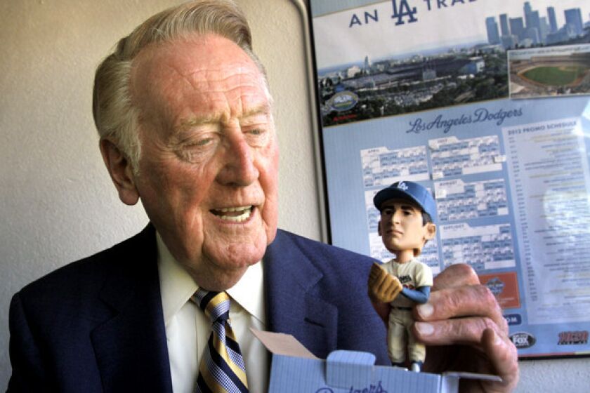 Dodgers broadcaster Vin Scully, taking a look at a Sandy Koufax bobblehead, has not ruled out working games beyond this season.