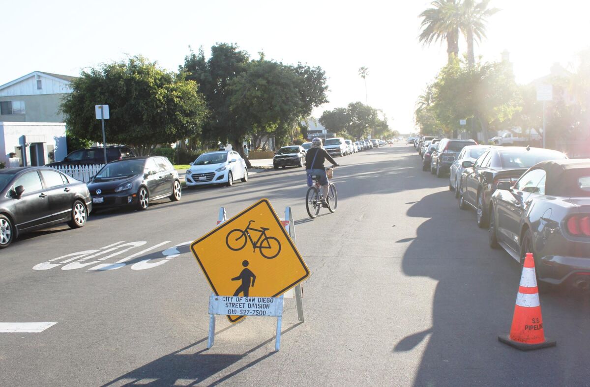 A bicyclist traveling on Diamond Street, which is partially closed to vehicle traffic due to its “Slow Street” designation.