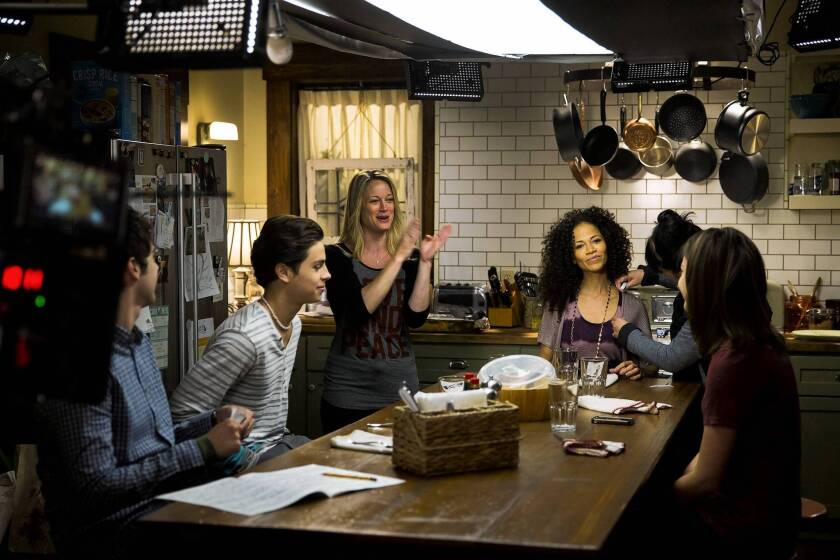Teri Polo, standing, and Sherri Saum (seated at center) star in "The Fosters."