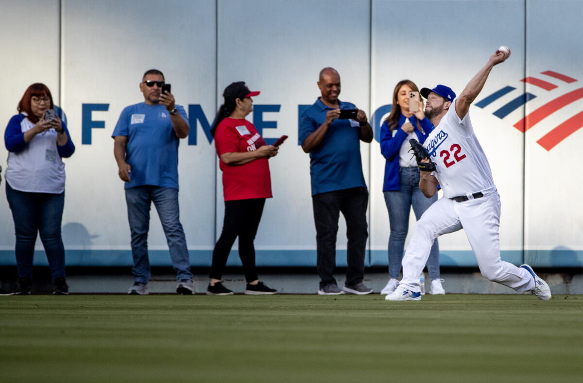 Clayton Kershaw, Cumartesi günkü Giants maçı öncesinde dış saha duvarının yakınında küçük bir taraftar grubunun önünde ısınıyor.