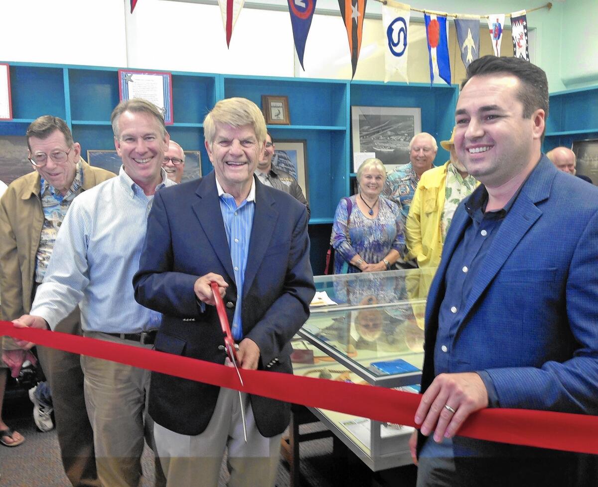Newport Beach Historical Society board member Howard Hall, city Library Services Director Tim Hetherton, board President Bernie Svalstad and Mayor Pro Tem Kevin Muldoon, from left, prepare to cut the ribbon Monday to celebrate the Historical Society's new room in the Balboa Branch Library. The Historical Society had not had a location of its own in its 49-year history.