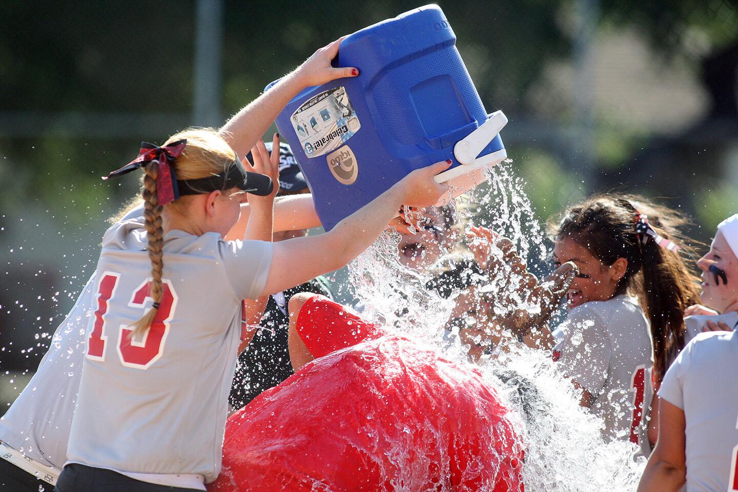 Glendale's head coach Gregory Martin is under a cold shower of ice water his team dumped on him after beating Hoover in a Pacific League softball game at Glendale High School on Thursday, May 15, 2014. Glendale won in 4 1/2 innings 10-0.
