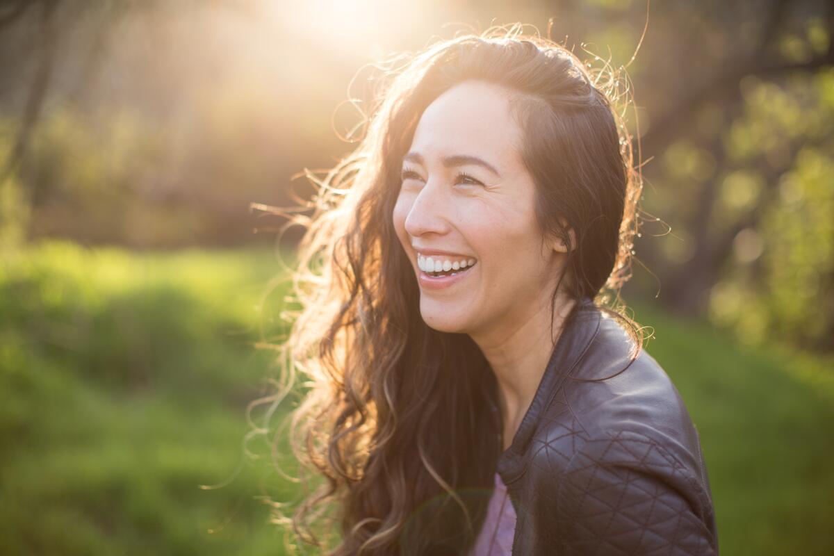 Marisa Quintanilla Griffeth smiles as the sun glows behind her.