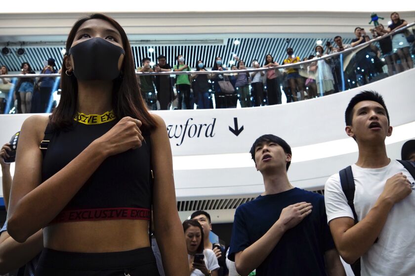 FILE - Demonstrators sing a theme song written by protestors "Glory to Hong Kong" at the Times Square shopping mall in Hong Kong, Sept. 12, 2019. Hong Kong’s government said Tuesday, June 6, 2023, it is seeking a court order to prohibit people from broadcasting or distributing the popular protest song “Glory to Hong Kong” after it was mistakenly played as the city’s anthem at several international sporting events in the past year.(AP Photo/Vincent Yu, File)