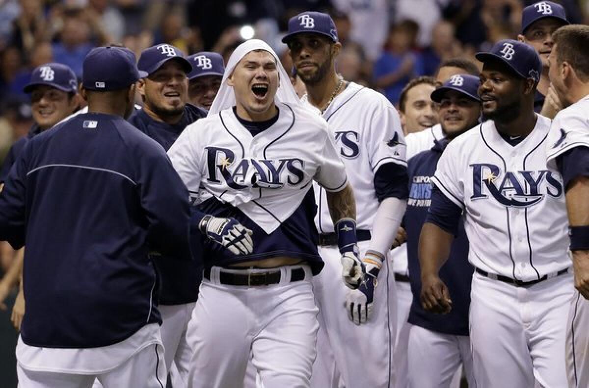 Tampa Bay's Jose Lobaton, center, celebrates with his teammate after hitting a walk-off home run in the ninth inning of the Rays' 5-4 win over the Boston Red Sox in Game 3 of the American League division series Monday.