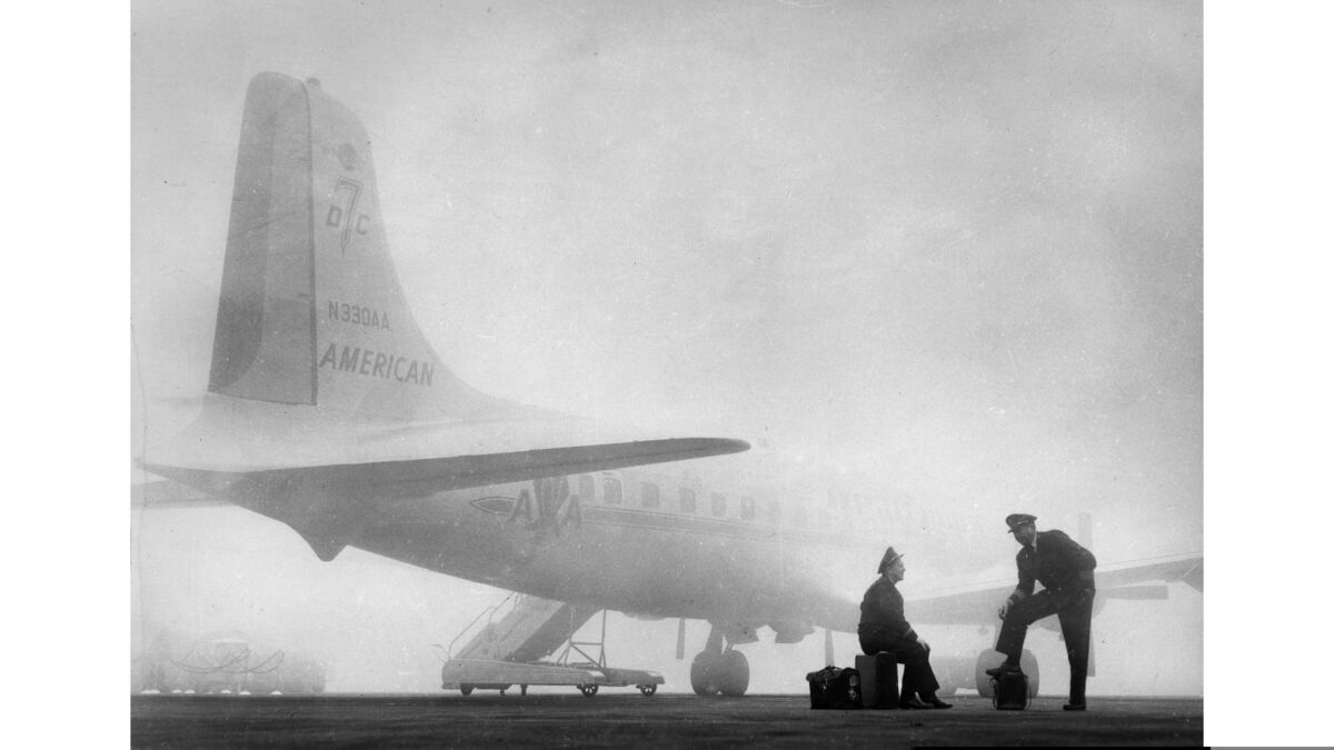 Jan. 29, 1958: American Airlines' flight engineer Frank Nusser, left, and Capt. Don Young wait by their aircraft for fog to lift at Los Angeles International Airport.
