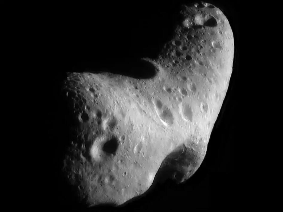 A pitted rock is seen in space.